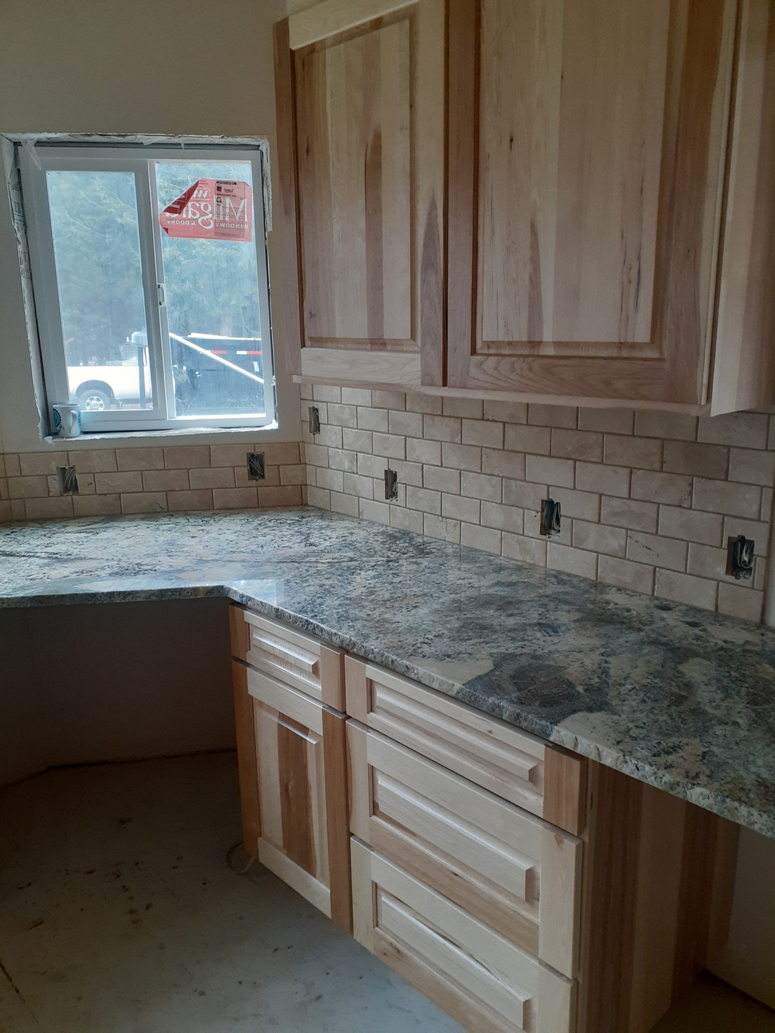 Kitchen with hickory cabinets, granite countertop and travertine subway tile backsplash