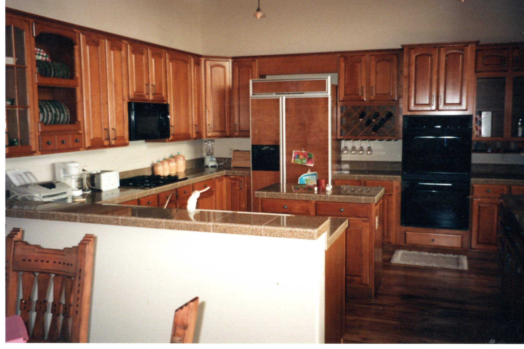 Kitchen with cherry raised panel cabinets, tiled countertops and a hardwood floor
